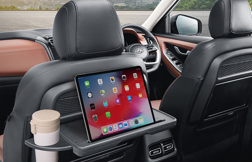 Front row seatback table with retractable cup-holder and IT device holder